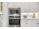 Kitchen features stainless steel microwave and oven, white cabinets, and quartz countertop at 1949 Skyfall Cir, Brookhaven, GA 30319