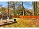 Serene backyard featuring a concrete patio, lush greenery, and a wooden fence, perfect for outdoor relaxation and entertaining at 5505 Longmeadow Ln, College Park, GA 30349