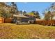 Spacious backyard with mature trees, a well-manicured lawn, and a wooden fence, providing privacy and tranquility at 5505 Longmeadow Ln, College Park, GA 30349