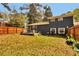 Expansive backyard featuring a well-kept lawn, a wooden fence, and a cozy patio area, ideal for outdoor living at 5505 Longmeadow Ln, College Park, GA 30349