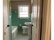 Classic bathroom with a pedestal sink, tiled walls, and a bathtub at 1271 Sanders Dr, Lake City, GA 30260