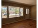 Bright living room with hardwood floors and large windows, offering a view of the neighborhood at 1271 Sanders Dr, Lake City, GA 30260