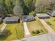 Aerial view of a single-story home surrounded by lush trees, green grass, and blue skies at 1703 Derrill Dr, Decatur, GA 30032