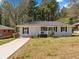 Well-maintained single-story home featuring a welcoming front porch, tidy landscaping, and a long driveway at 1703 Derrill Dr, Decatur, GA 30032