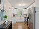 Well-lit kitchen features white cabinets, hardwood floors, stainless steel appliances and a stylish marble backsplash at 1703 Derrill Dr, Decatur, GA 30032