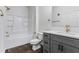 Bathroom featuring white tiling in the bathtub shower and vanity with a grey cabinet, and modern gold-tone fixtures at 400 17Th Nw St # 1133, Atlanta, GA 30363