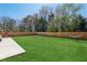 An expansive backyard features lush green grass, a wooden fence, and patio seating for relaxation and outdoor enjoyment at 4257 Freight St, Tucker, GA 30084