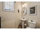 Chic powder room with pedestal sink, modern fixtures, and stylish patterned wallpaper at 4257 Freight St, Tucker, GA 30084
