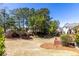 Beautiful backyard with well-maintained lawn, landscaping, trees, and a view of the neighborhood at 1037 Windermere Xing, Cumming, GA 30041