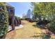 Large backyard with lush grass, brick patio, stairs, trees, and landscaping at 1037 Windermere Xing, Cumming, GA 30041
