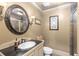 Bathroom featuring dark vanity, toilet, walk-in shower and wall decor at 1037 Windermere Xing, Cumming, GA 30041