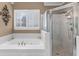 Bathroom showcasing a soaking tub, decorative wall art, and a tiled walk-in shower at 1037 Windermere Xing, Cumming, GA 30041
