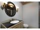 Elegant bathroom featuring a unique mirror, granite countertop, sink, toilet, and sconce lighting at 1037 Windermere Xing, Cumming, GA 30041
