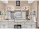 Bathroom featuring dual granite sinks, large mirror, and lots of cabinetry for storage at 1037 Windermere Xing, Cumming, GA 30041