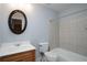 Neutral bathroom featuring a wooden vanity, toilet, and tiled tub and shower at 1037 Windermere Xing, Cumming, GA 30041
