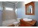 Cozy bathroom featuring tiled tub, shower combination, and vanity with framed mirror at 1037 Windermere Xing, Cumming, GA 30041