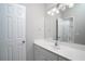Bathroom with a bright mirror, white cabinets, countertops, sink, and light fixture at 1037 Windermere Xing, Cumming, GA 30041
