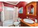 Cozy bathroom with wood vanity, shower and tub with patterned shower curtain, and window at 1037 Windermere Xing, Cumming, GA 30041