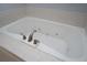 Close-up of a soaking tub with jets and brushed metal faucet at 1037 Windermere Xing, Cumming, GA 30041