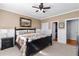 Well-lit bedroom features a floral comforter, dark furniture, neutral walls, and a ceiling fan at 1037 Windermere Xing, Cumming, GA 30041