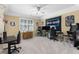 Spacious room with beige walls, two desks, a large window and ceiling fan, perfect for a recreational room at 1037 Windermere Xing, Cumming, GA 30041