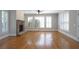 Cozy living area featuring hardwood floors, a stone fireplace, and abundant natural light at 1037 Windermere Xing, Cumming, GA 30041