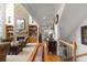Open concept living room with stone fireplace, built-in shelving, hardwood floors and staircase at 1037 Windermere Xing, Cumming, GA 30041