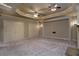 Large entertainment room with neutral color, tray ceiling, recessed lights, and double doors at 1037 Windermere Xing, Cumming, GA 30041