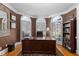 This home office features a large wooden desk, hardwood floors, and bright natural light from three large windows at 1037 Windermere Xing, Cumming, GA 30041