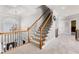 Carpeted staircase with wooden railing and iron spindles leads to the upper level at 1037 Windermere Xing, Cumming, GA 30041
