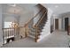Carpeted staircase with decorative iron railing and chandelier above the entryway at 1037 Windermere Xing, Cumming, GA 30041