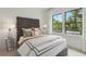 A bright bedroom with large windows, a tufted headboard, and views of the lush greenery outside at 1283 Forsyth Park Rd, Decatur, GA 30033