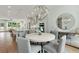 Dining room with modern light fixture, kitchen view, and round mirror at 1283 Forsyth Park Rd, Decatur, GA 30033