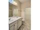 Bright bathroom with double sinks, white cabinetry, and tile flooring at 1705 Rolling View Dr, Cumming, GA 30040