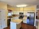 Kitchen features stainless appliances, center island, wood floors and plentiful cabinet space at 1705 Rolling View Dr, Cumming, GA 30040