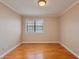 This bedroom has hardwood floors, neutral walls, bright lighting, and a window at 1687 Briarcliff Ne Rd # 8, Atlanta, GA 30306