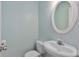 Clean powder room featuring a pedestal sink, oval mirror, and light blue walls at 1687 Briarcliff Ne Rd # 8, Atlanta, GA 30306
