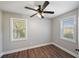 Cozy bedroom with wood floors, two windows letting in natural light, and neutral wall paint at 1800 E Lake Rd, Mcdonough, GA 30252