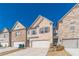 Attractive townhome displays a two-car garage and brick facade under a clear blue sky at 2463 Quay Rdg, Lawrenceville, GA 30044