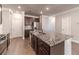Well-lit kitchen offers granite counters, stainless steel appliances, a center island, and dark wood cabinetry at 2463 Quay Rdg, Lawrenceville, GA 30044