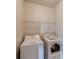 This clean laundry room features a washing machine, dryer, and convenient overhead shelving for storage at 2463 Quay Rdg, Lawrenceville, GA 30044