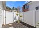 Private backyard with a white fence and a charming angel statue surrounded by lush greenery and hanging flower baskets at 281 Hiawassee Dr, Woodstock, GA 30188