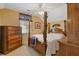 Bedroom with a four poster bed, ceiling fan, floral accents, and a large chest of drawers with a window view at 281 Hiawassee Dr, Woodstock, GA 30188