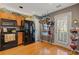 Traditional kitchen with wooden cabinets, black appliances, and hardwood floors at 281 Hiawassee Dr, Woodstock, GA 30188