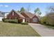 Charming red brick home features a manicured lawn, mature landscaping, and traditional architectural details at 625 Sycamore Glen Nw Ct, Lawrenceville, GA 30044