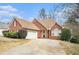 Beautiful brick home features a well-manicured front lawn, a long driveway, and a two-car garage at 625 Sycamore Glen Nw Ct, Lawrenceville, GA 30044
