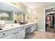 Main bathroom featuring a long vanity with dual sinks, makeup counter, walk-in closet and tile floor at 625 Sycamore Glen Nw Ct, Lawrenceville, GA 30044