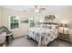 Bright bedroom featuring neutral colors, two windows, ceiling fan, and comfortable bed with side tables at 1945 Wenlok Ne Trl, Marietta, GA 30066