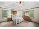 Bright bedroom featuring a tray ceiling, soft carpet, and an elegant, natural wood furniture set at 1945 Wenlok Ne Trl, Marietta, GA 30066