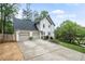 Charming home exterior featuring a two-car garage, ample parking, and manicured lawn at 1945 Wenlok Ne Trl, Marietta, GA 30066